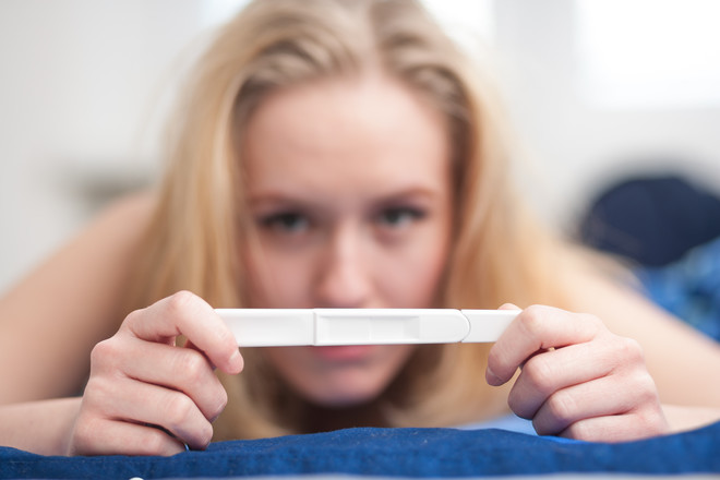61a2dd57073551b0ca5dfafc619ff5efb4bc44d1 woman looking at pregnancy test