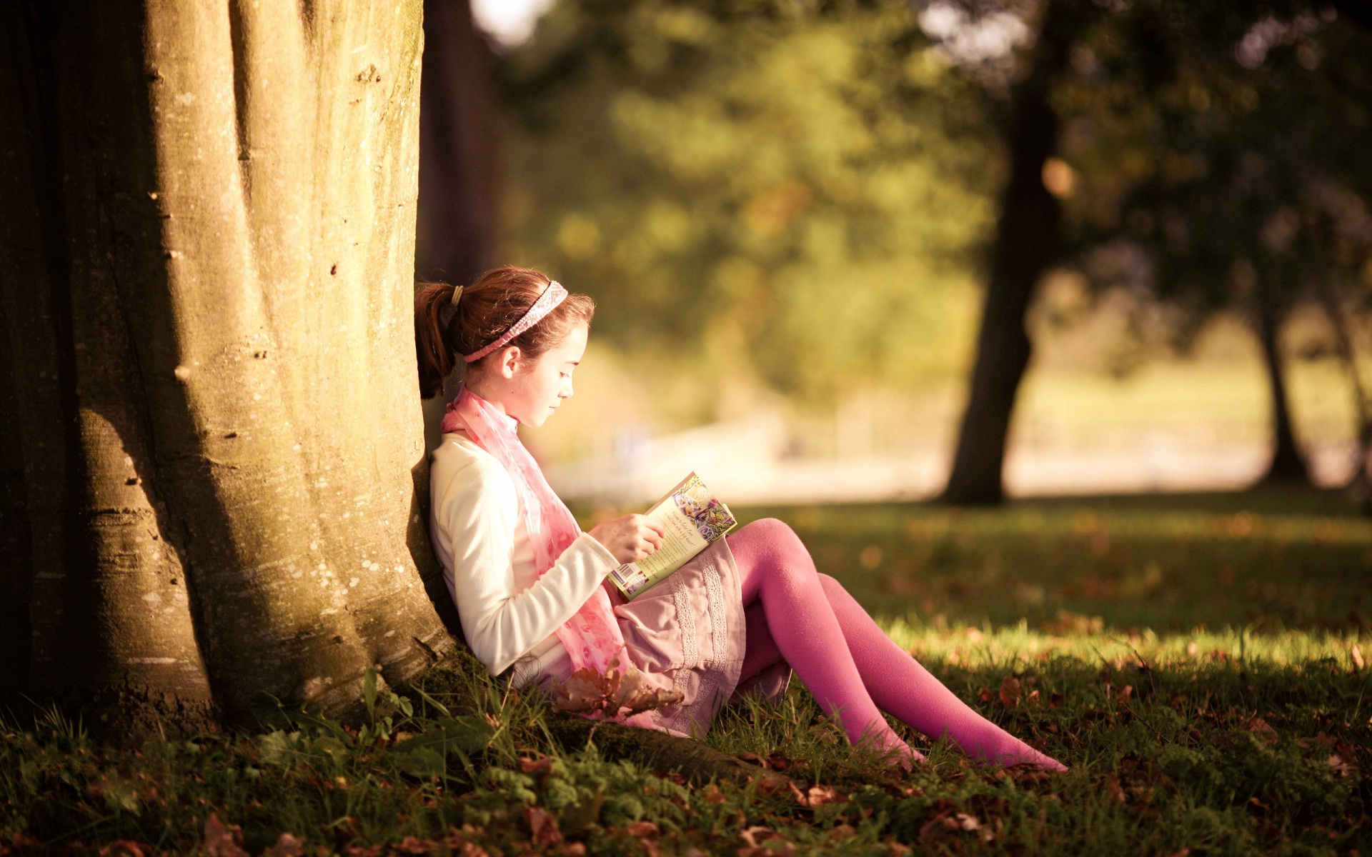 baby reading book in garden