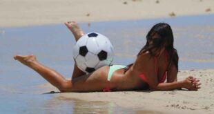 Η Claudia Romani κυλιέται στην άμμο για μια μπάλα