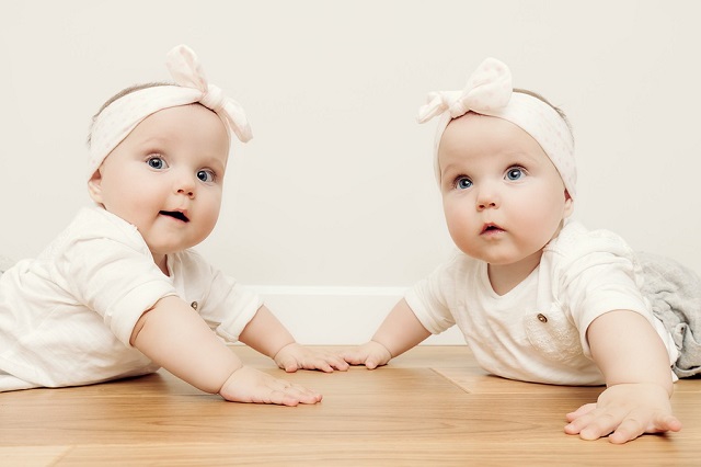 bigstock Cute baby twin sisters crawl t 148915172