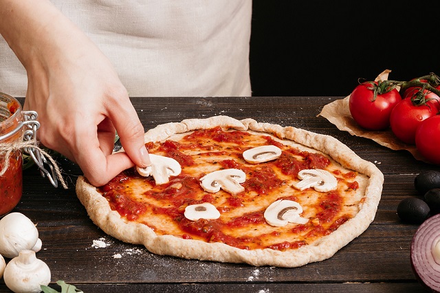 bigstock Cooking Pizza Hands Adding Fr 179719735