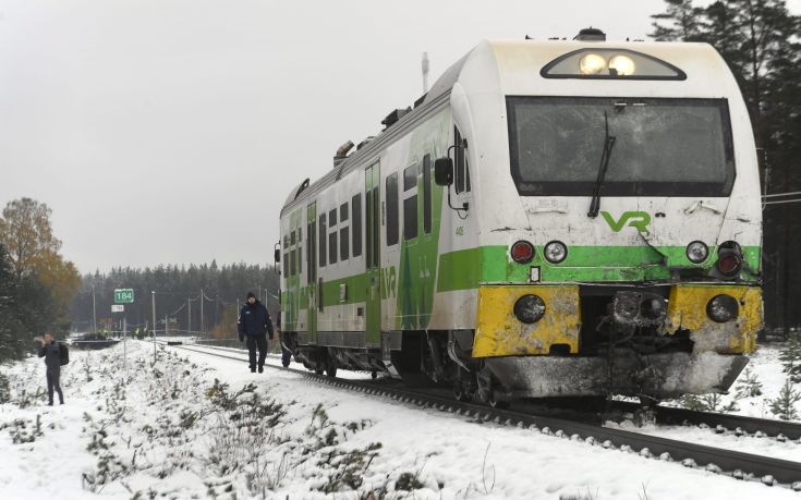 A police officer walks alongside a train that was involved in a crash with a military truck in which several people were killed in southern Finland Thursday Oct. 26, 2017. Finnish media say several people have been killed in a train crash in the southern part of Finland. (Lehtikuva via AP)