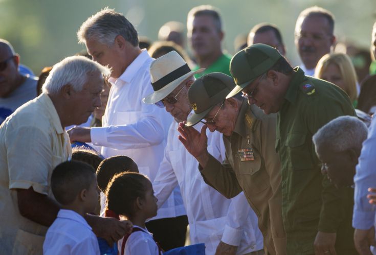 Cuba's President Raul Castro, center, salutes school children during an event paying tribute to Cuban Revolution hero Ernesto “Che” Guevara marking the 50th anniversary of his death in Santa Clara, Cuba, Sunday, Oct. 8, 2017. (AP Photo/Desmond Boylan)