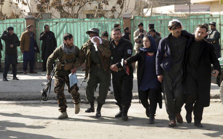 Wounded people are assisted at the site of a deadly suicide attack in the center of Kabul, Afghanistan, Saturday, Jan. 27, 2018. Afghan Public Health Ministry says dozens have been killed and over 100 wounded in suicide car bomb attack in capital Kabul. (AP Photo/Massoud Hossaini)