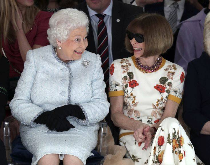 FILE - This is a Tuesday, Feb. 20, 2018 file photo of Britain's Queen Elizabeth as she sits next to fashion editor Anna Wintour as they view Richard Quinn's runway show before presenting him with the inaugural Queen Elizabeth II Award for British Design, as she visits London Fashion Week's BFC Show Space in central London (Yui Mok/ Pool photo/ File via AP)