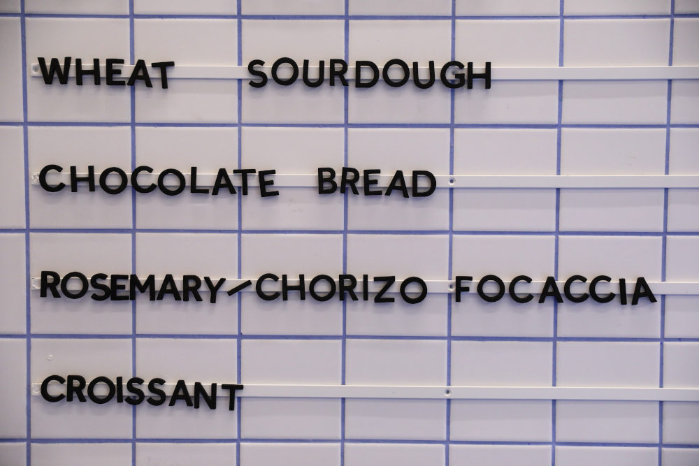 Σαν σε μικροσκοπικό σινεμά τα γραμματάκια στον τοίχο ενημερώνουν τους πελάτες για τα προϊόντα του φούρνου / Φωτογραφία: Sooc