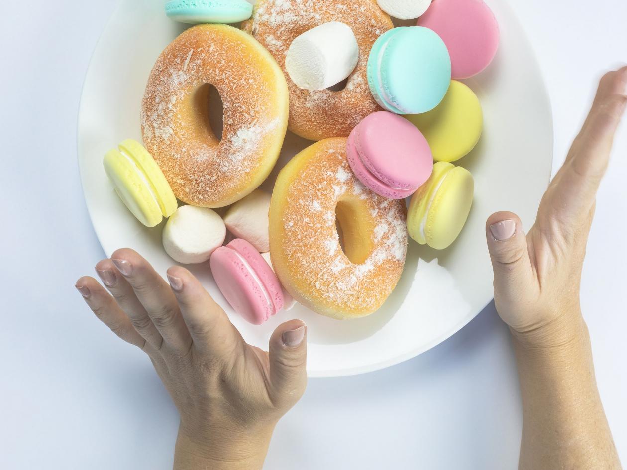 Woman Hands Making A Hand Sign Of No And Refuse For A White Plate With Fastfood And Sugar, Top View,
