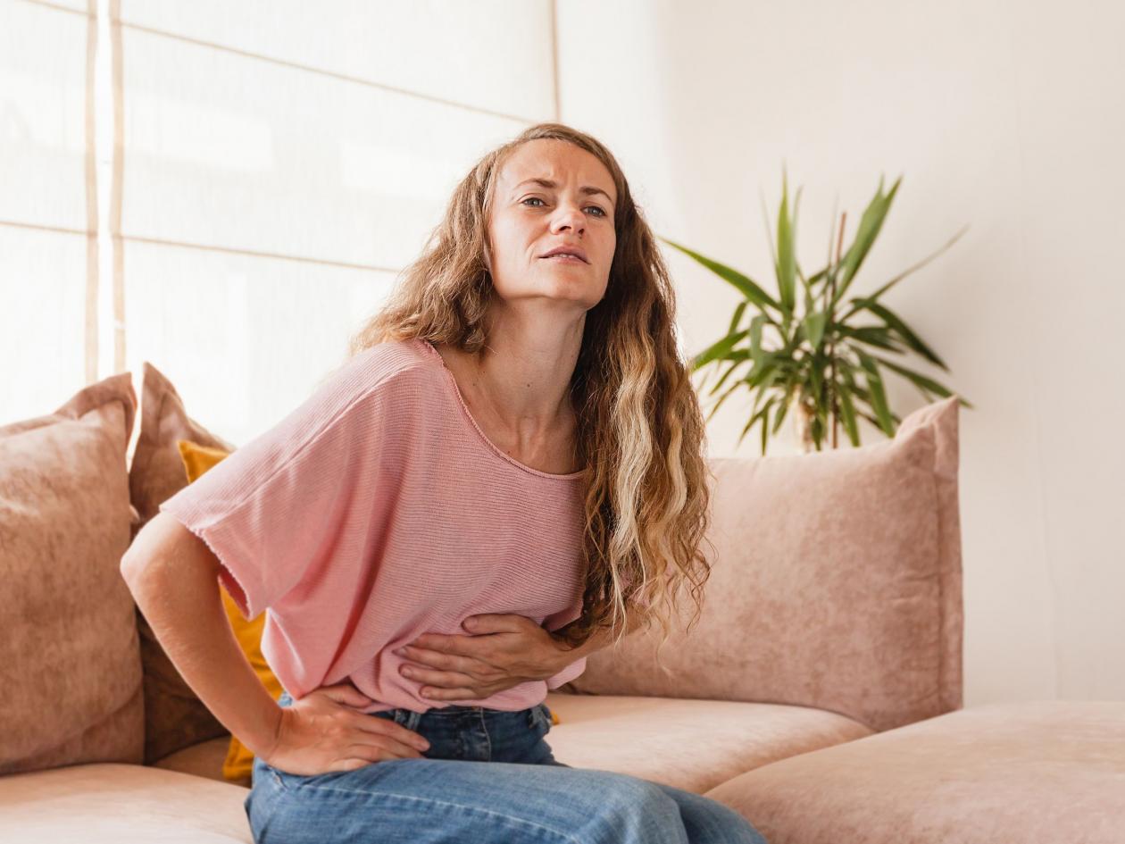 Woman having painful stomach ache. Female suffering from abdominal pain. Pain in the abdomen due to