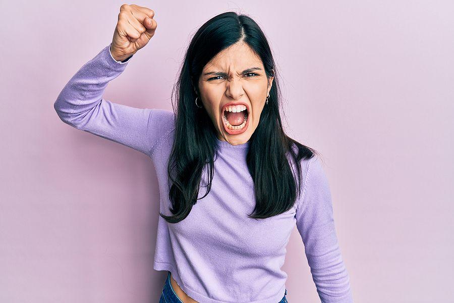 Young hispanic woman wearing casual clothes angry and mad raising fist frustrated and furious while