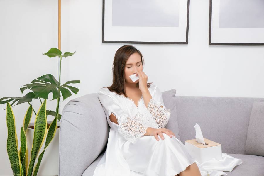 Symptoms Of Allergic Rhinitis In Women. Sick Woman In White Nightwear With A Cold Blowing Her Nose I