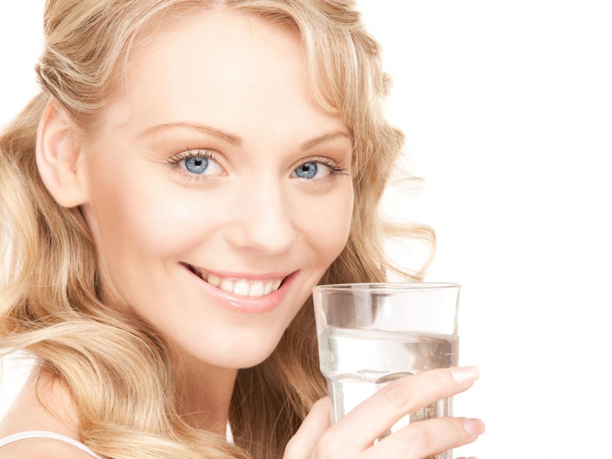 beautiful woman with glass of water over white