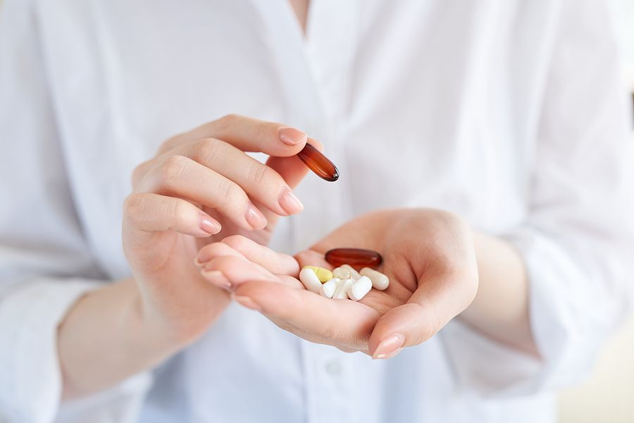 Vitamins And Supplements. Closeup Of Hand Holding Variety Of White Pills On Palm. Close-up Of Medica