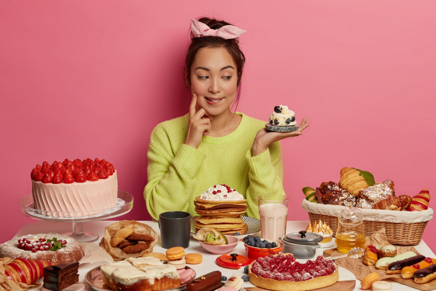 So Much Delicacy. Pretty Thoughtful Korean Woman Looks With Appetite At Tasty Creamy Dessert, Eats S