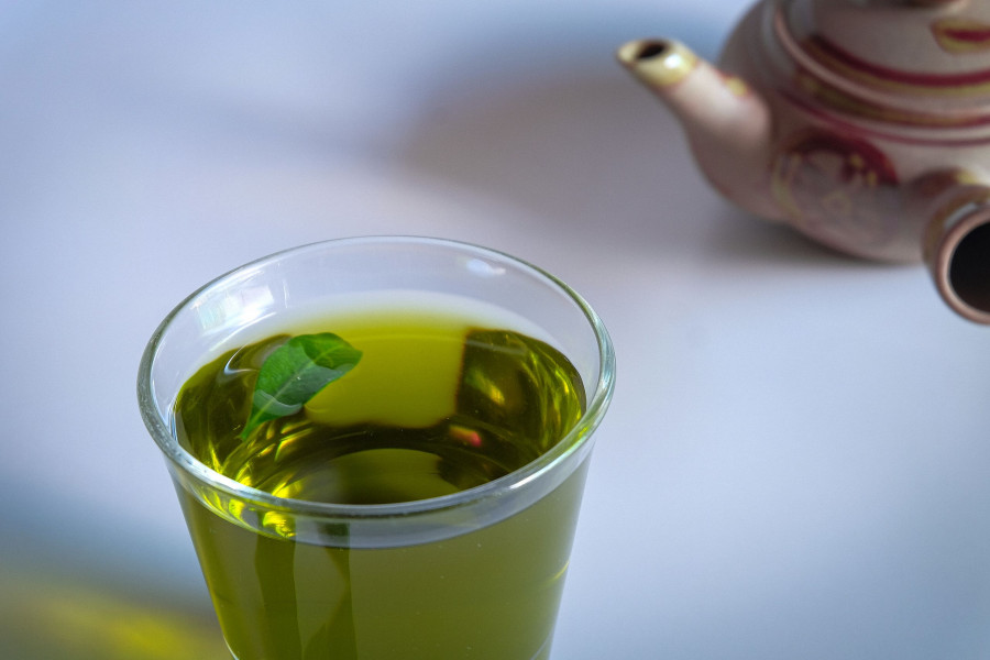 Hot Green Tea With Tea Leaves And Vintage Tea Pot Clay.